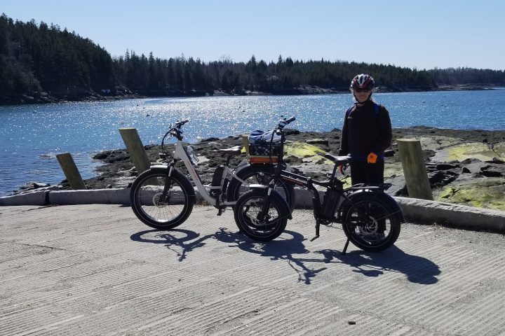 a man sitting on a motorcycle with a body of water